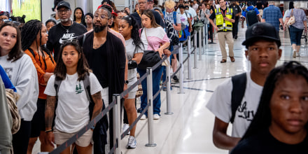 Travelers stand in a long line