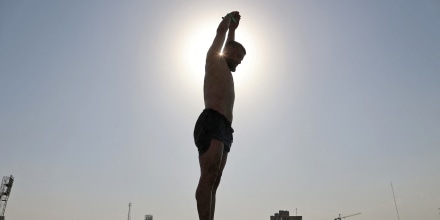 Iranian man jumps into a pool during the heatwave in Tehran