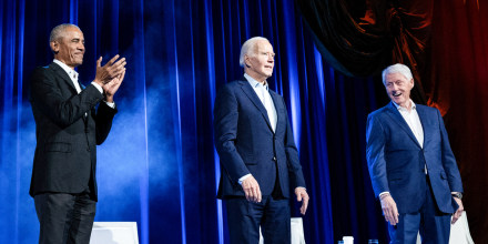 Barack Obama, Joe Biden, and Bill Clinton stand next to each other on stage