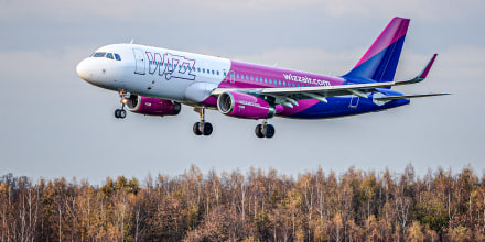 A Wizz Air plane flies above land