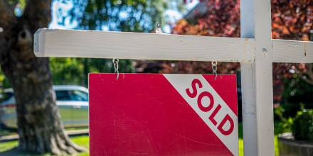 A "Sold" sign in front of a home.