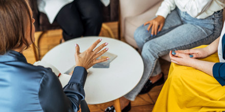 Four women in armchairs and talking.