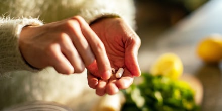 Young woman taking a health supplement in the kitchen.