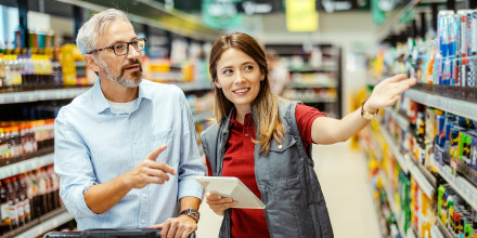 Supermarkets worker assisting a male shopper.