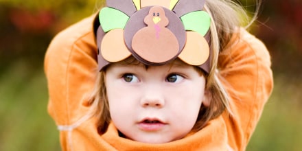 A girl wearing a Thanksgiving turkey headdress