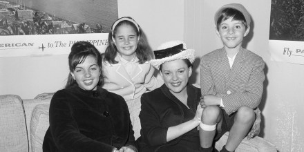 Singer Judy Garland (R) waits with children (left to right) Liza Minnelli, age 16, the daughter of a previous marriage, Lorna Luft, age 9, and Joey Luft, age 7, children of her estranged husband Sid Luft, at New York's Idlewild Airport.