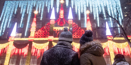 A couple covered in snow watches the Holiday lights at Saks Fifth Avenue during a snow storm  on December 16, 2020 in New York City. 