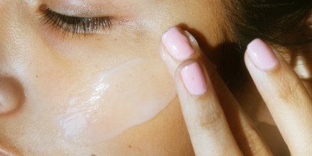 a woman putting on a thick moisturizer on her face