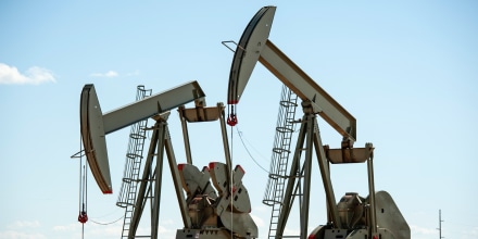 Two pumpjacks are seen next to each other outside