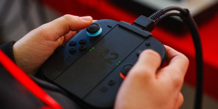 A guest holds a Nintendo Switch 2 video-game console system at the Nintendo's worldwide presentation in Paris on April 2, 2025. 