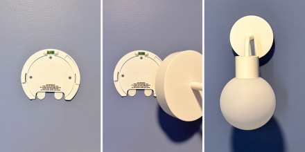 Poplight base adhered to blue wall with person holding Poplight with shade.