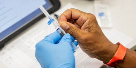 A photo of a nurse's hands as she prepares to administer a flu shot
