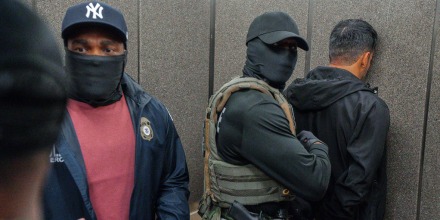 Agentes de ICE escoltan a un inmigrante detenido hacia un ascensor tras salir de una corte el 17 de junio de 2025, en Nueva York.