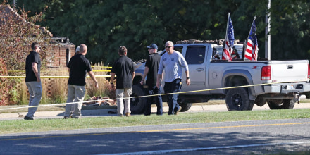 Law enforcement officials next to the vehicle used to ram the exterior of the Church of Jesus Christ of Latter-day Saints in Grand Blanc Township, Mich.