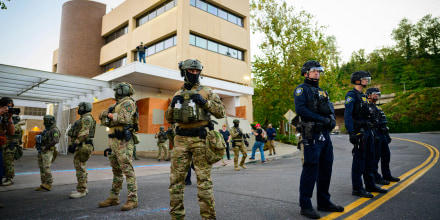 Federal agents, including members of the Department of Homeland Security, stand guard outside an Immigration and Customs Enforcement (ICE) facility in downtown Portland, Oregon, on Oct. 6, 2025. 