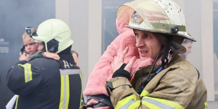 Firefighters evacuate children following a Russian drone strike on a kindergarten