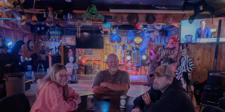 (L-R) Renae Altman, 58, Joe Brewer, 68, and Roger Valk, 72 from Oologah, Okla. sit at the Ironhorse Saloon on Tuesday. When asked about immigration they expressed hatred for immigrants and trans people.