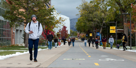 Students walk through campus down a street