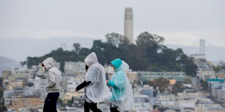 People wear rain ponchos;