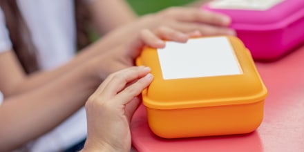 Close up picture of hands on luhcn boxes