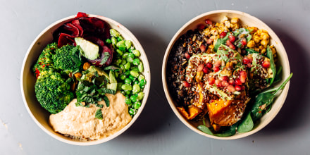 Vegan bowls with various vegetables, hummus and seeds on the table, directly above view