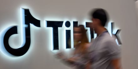 Web Summit attendees walk past the TikTok pavilion