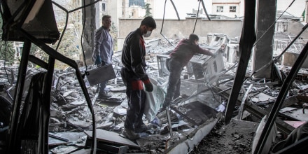People work to recover items from a building hit by a strike