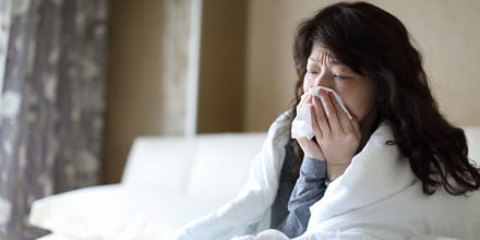 Sick woman blowing her nose