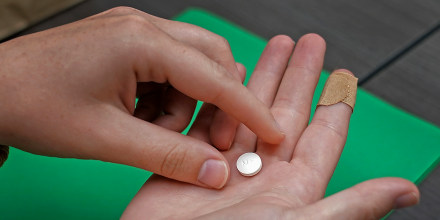 A patient prepares to take the first of two combination pills, mifepristone.