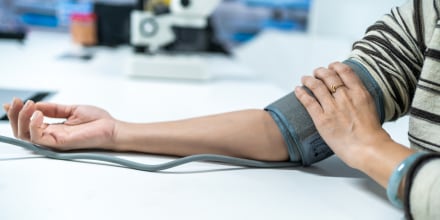 A pair of female hands measure blood pressure