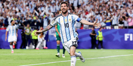 Lionel Messi runs on the soccer field in celebration