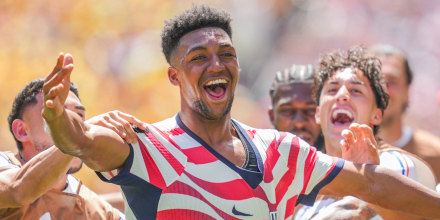 Alex Freeman of the United States celebrates a goal surrounded by teammates on the soccer field