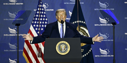 Donald Trump speaking at a podium with the Presidential seal on it.