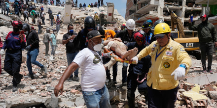 Voluntarios haciendo de rescatistas cargan a Daniel Cordero en una camilla después de haberlo sacado de entre los escombros en Catia La Mar, Venezuela, el 26 de junio de 2026.