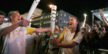 Image: Model Adriana Lima carries the Olympic torch with Rio de Janeiro's Secretary of Tourism Antonio Pedro in Maua Square in Rio de Janeiro