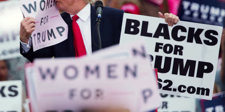 Image: Trump kisses a \"Women for Trump\" sign during a campaign rally