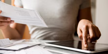 Image; Woman paying bills with digital tablet