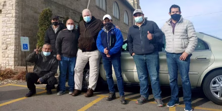 The six construction workers from Texas who stopped receiving pay for their work in Cedar Rapids, Iowa flank John Greve, pastor of Grace Episcopal Church, who fed and housed them after the learning of their situation.