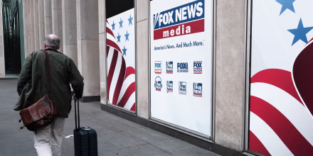 People walk by the News Corporation headquarters, home to Fox News in New York