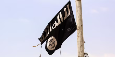 A member of the US-backed Syrian Democratic Forces removes an ISIS flag in Taqba, Syria, on April 30, 2017.