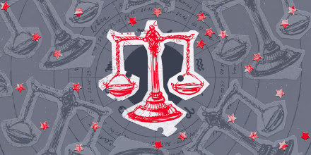 Paper cutouts of the Libra zodiac on a gray background