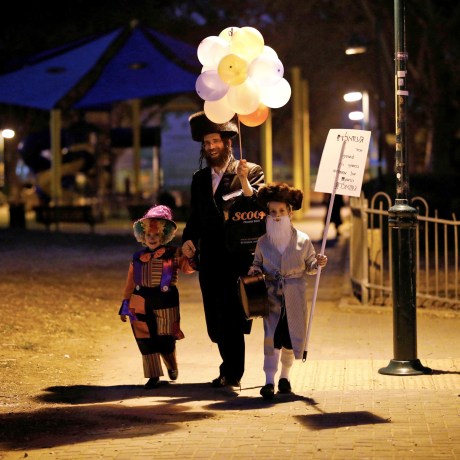 Image: An Ultra Orthodox Jewish family dressed in costumes walk during the Jewish holiday of Purim, Israel