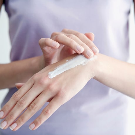 Image: Woman applying cream to hands, close-up