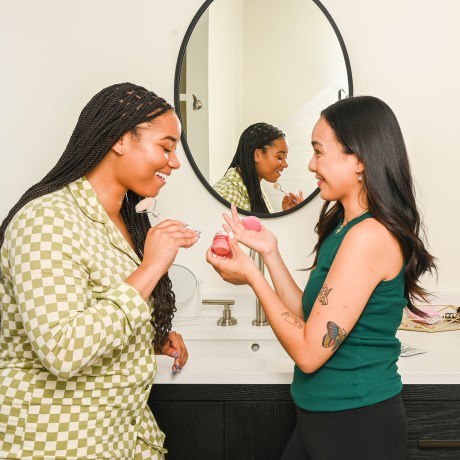 Two friends sharing beauty tips in the bathroom