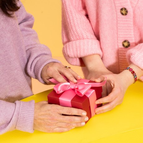 Two hands holding onto a gift basket