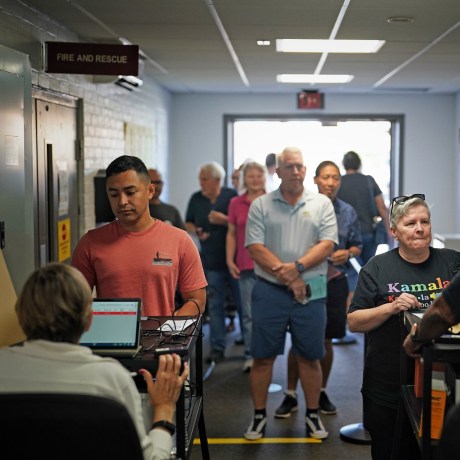 People wait in line to vote on the first day of early voting in Virginia at a voting center in Manassas, Va.