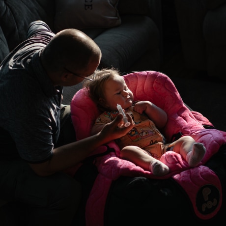 Patrick Lazoen feeds his daughter Emmalyn a bottle that contains her medicines.