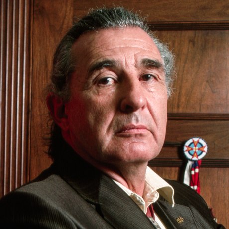 Ben Nighthorse Campbell poses next to a Native American headdress