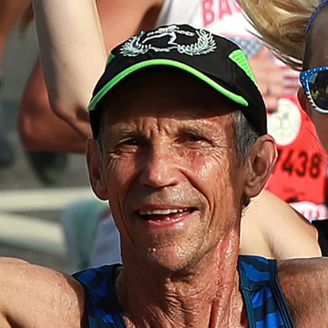 Jeff Galloway running as he gived his thumbs up.