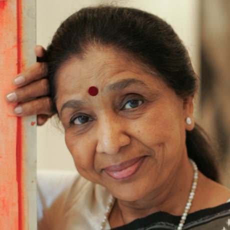 Asha Boshe leans up against an entryway and smiles for a portrait